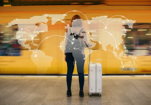 Person,With,Luggage,Stands,In,Front,Of,A,Yellow,Train,