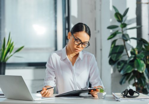 Asian,Translator,In,Eyeglasses,Working,Online,With,Laptop,And,Documents